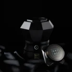Oudgasm Diamond Bakhoor Burner on black silk beside a small Kayali bakhoor jar