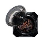 Open black Vanilla Oud bakhoor jar filled with dark oud wood chips, lid resting beside it