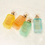 Four Vacay bottles — Capri, Marrakesh, Maui and Maldives — lying on white silk