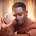 Man holding the Freedom Musk Santal | 34 bottle near his face