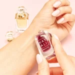 Hand holding the Vanilla | 28 mini near a wrist, with the Freedom Musk Santal mini behind it