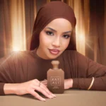 Freedom Musk Latte | 41 woman in brown with the bottle standing on a table in front of her