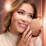 Smiling woman holding a Freedom Musk Matcha | 45 bottle against her cheek