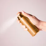 Hand holding a Vanilla | 28 Body Spray can spraying mist