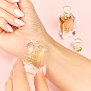 Hand holding the Yum Boujee Marshmallow mini near a wrist, with the second mini beside it