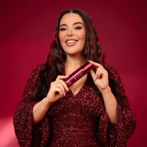 Woman in a red sequin top holding a Lovefest Burning Cherry | 48 Body Spray can
