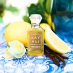 Vacay in a Bottle Capri in a Bottle Lemon Sugar | 14 bottle with lemons and vanilla pods on a blue patterned cloth