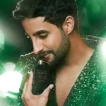 Man holding an Oudgasm Tobacco Oud | 04 bottle near his face