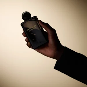 Hand holding a black Dapper Daddy Saffron Oud bottle