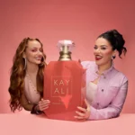 Two women holding an Eden Sparkling Lychee | 39 Kayali Eau de Parfum bottle